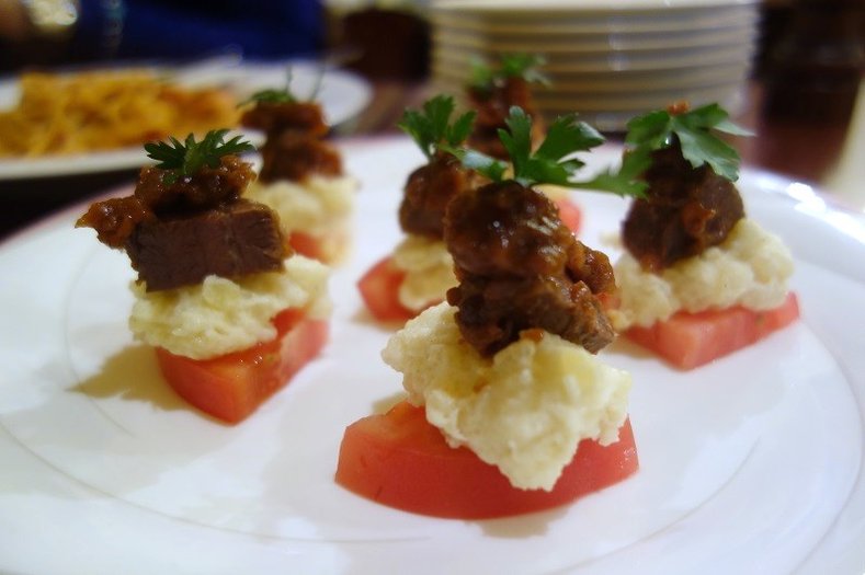 野菜と一緒に味わう、見た目もお洒落な鹿肉とトマトのクロスティーニの写真
