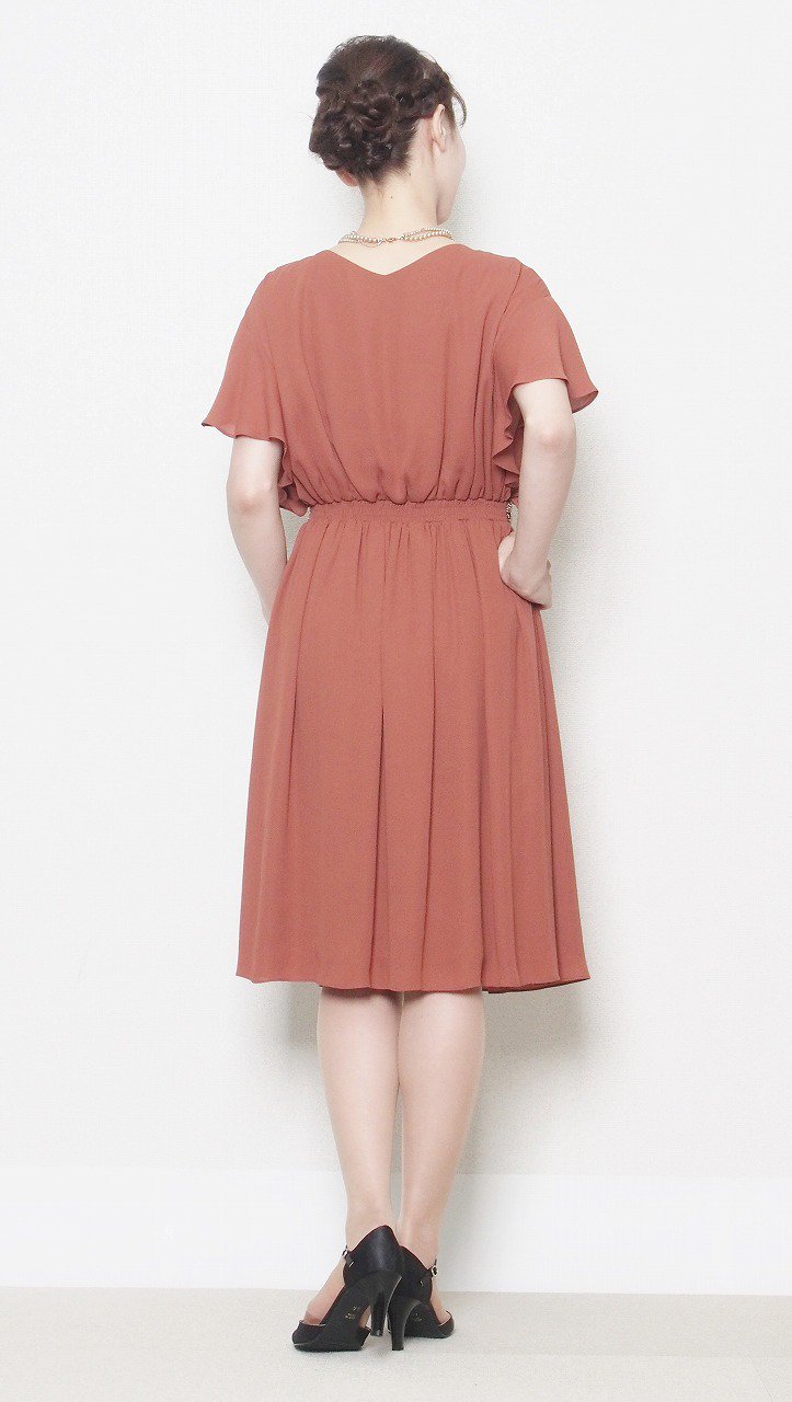 レンタルドレスのニュアンスカラー テラコッタオレンジのウエストデコレーションドレスの後ろ姿