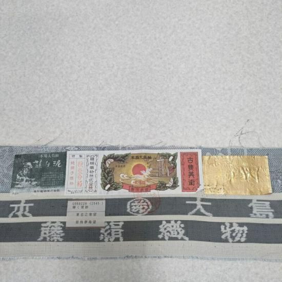 都喜ヱ門　ゴールドラベル　小紋　白大島紬　菊　蝶　藤白泥染　着物　032a d 本場大島紬 都喜ヱ門 証紙付き 金ラベル 純泥染 茶泥 正絹 10403