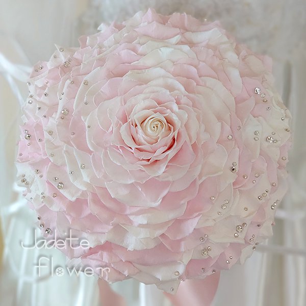 プリザーブドフラワーのホワイトと薄ピンクのバラをグラデーションに幾重にも重ねて作ったメリアブーケ。スワロフスキーラインストーンを散りばめた豪華なデザインです。