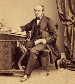 John Couch Adams(1819-1892)sitting at a Davenport desk